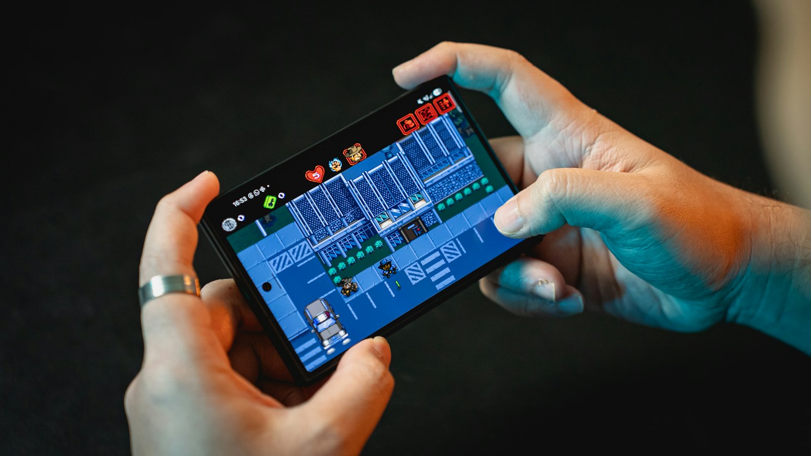 Tangan memainkan game di layar smartphone gaming